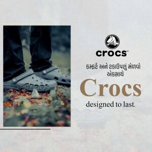 Person wearing grey Crocs shoes on a fall background with Crocs logo and text.