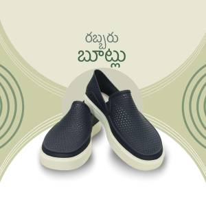 A pair of navy blue Crocs with a white sole, displayed against a light green and white background.