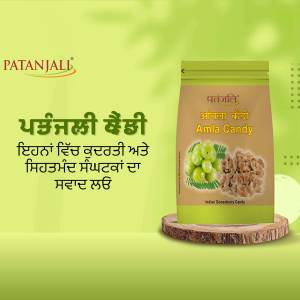 Patanjali Amla Candy packaging on a wooden base with green background