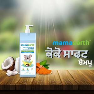 Mamaearth Baby Shampoo bottle with coconut and orange ingredients on a wooden surface