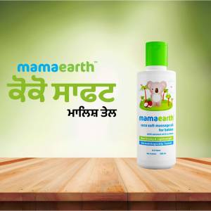 Mamaearth Baby Massage Oil bottle on a wooden surface