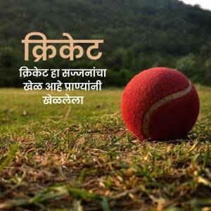 A red cricket ball on a grassy field with text in Marathi
