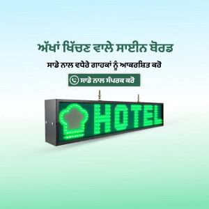 A lit green 'Hotel' sign with Punjabi text on a light blue background.