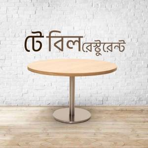 A wooden table and chair in front of a brick wall with Bengali text.