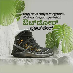 Black and grey Salomon hiking boots displayed on a rock with tropical leaves