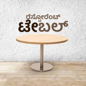 Round wooden coffee table in front of a brick wall with text in Kannada
