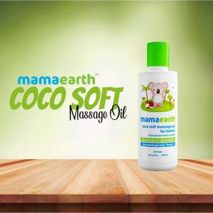 Mamaearth Coco Soft Massage Oil bottle on a wooden surface