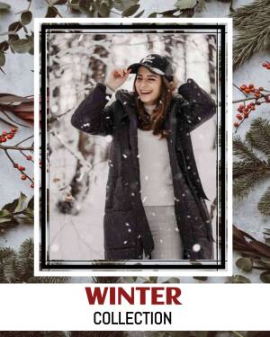 Woman wearing a black puffer coat and cap in a snowy forest, promoting a winter collection.