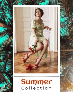 Woman in a light green floral dress and red heels posing with red flowers