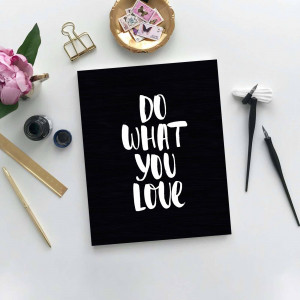 Flat lay of a black card with white text 'Do What You Love' surrounded by stationery items.