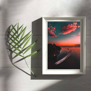 Framed sunset landscape with a palm leaf shadow