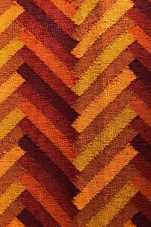 Close-up of a textured surface with a chevron pattern in shades of orange and brown.