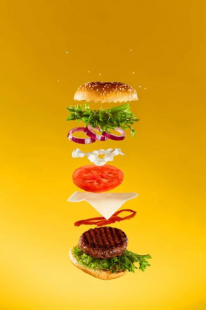 A visually striking image of a burger with its ingredients suspended in mid-air.