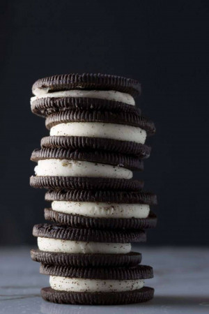 A tall stack of Oreo cookies against a dark gray background.