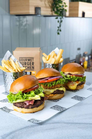 Close-up of gourmet burgers and french fries in a restaurant setting