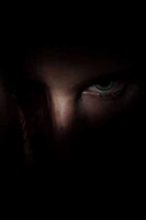 Close-up of a human eye partially obscured by shadow