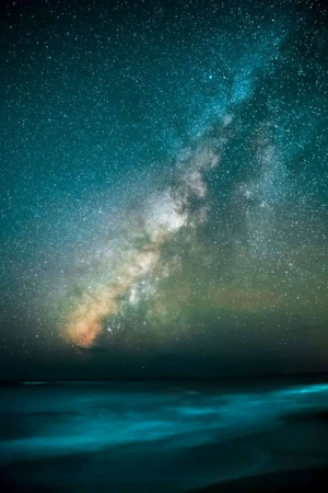 Stunning view of the Milky Way galaxy stretching across a night sky over a calm ocean.