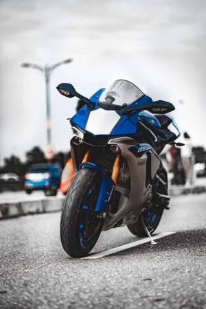 A blue Yamaha R1 motorcycle parked on the side of a road.