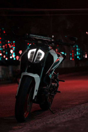 Motorcycle parked on a street with blurred bokeh lights in the background
