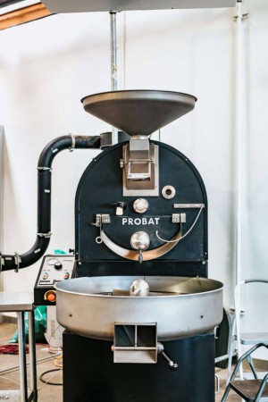 Close-up of a black Probat coffee roaster machine in a coffee shop