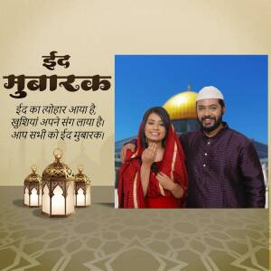 A couple wishing Eid Mubarak with a mosque and lanterns in the background.