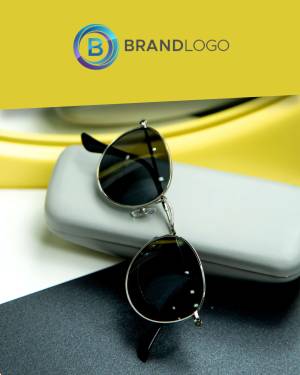 Close-up of silver-framed sunglasses resting on a white case with a yellow background and brand logo.