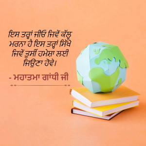 Paper Earth globe resting on a stack of books with Punjabi text