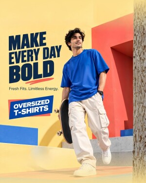 Young man wearing a bright blue oversized t-shirt and cargo pants holding a skateboard against a colorful abstract wall.