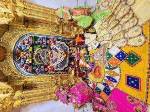 Close-up of a beautifully decorated Hanuman shrine with offerings and vibrant textiles.
