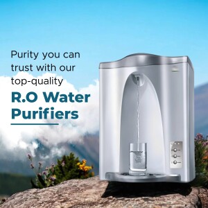 Silver RO water purifier dispensing water into a glass with a mountain backdrop.