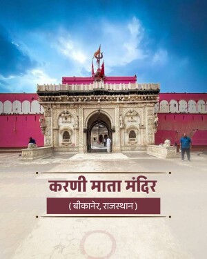 The intricately carved white marble gateway of the Karni Mata Temple in Bikaner against a vibrant pink wall and blue sky.