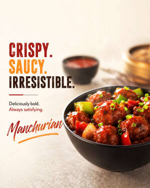 A bowl of crispy saucy Veg Manchurian served in a black bowl