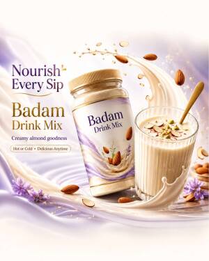A jar and a glass of creamy Badam drink mix surrounded by splashing milk and almonds.