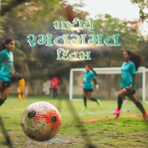 A group of young girls playing football on a grassy field with a soccer ball in the foreground.