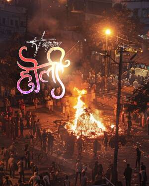 A bonfire burning during a Happy Holi celebration with people gathered around.