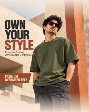 A man wearing a premium olive green oversized t-shirt in an architectural setting