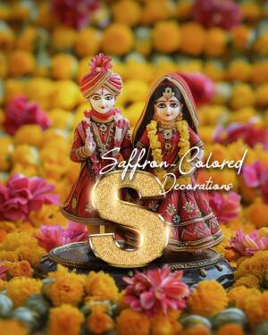 Two Indian wedding dolls, a groom and a bride, surrounded by marigold flowers and a golden letter 'S'.