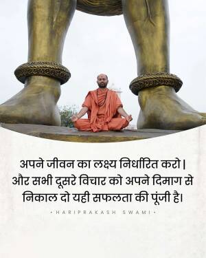 A monk meditating in front of large Buddha feet statues.