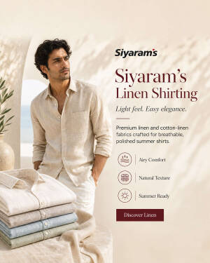 A man wearing a stylish Siyaram's linen shirt with folded linen shirts on a table in the foreground.
