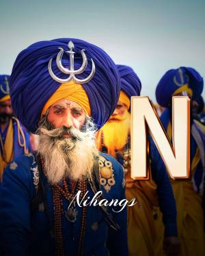 Close-up of a Nihang Sikh warrior with a large blue turban and traditional attire.
