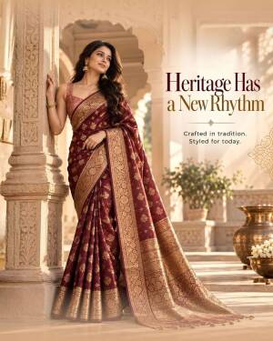 A woman wearing a beautiful maroon Banarasi silk saree with golden embroidery in a traditional setting