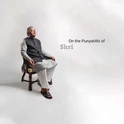 A somber portrait of an elderly man sitting on a wooden chair against a light gray background with text reading On the Punyatithi of Shri