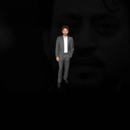 Irrfan Khan standing in a suit against a dark background