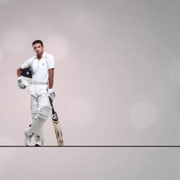 A professional cricket batsman standing in full uniform with a cricket bat against a soft grey background.