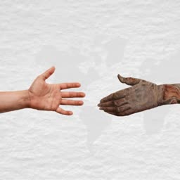 Two distinct hands reaching towards each other over a faded world map background