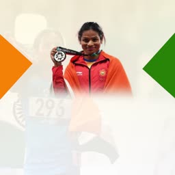 An Indian female athlete holding a medal draped in the Indian flag