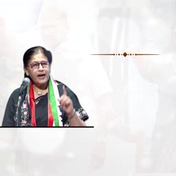 A woman in glasses wearing a tricolor scarf giving a passionate political speech
