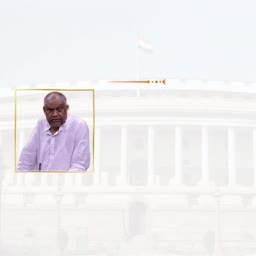 A portrait of an Indian politician wearing a white kurta in front of the Parliament building