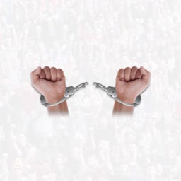 Two clenched human fists with broken handcuffs on a crowd background