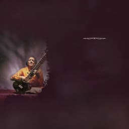 Ravi Shankar playing the sitar in a dim-lit studio setting with a dark background